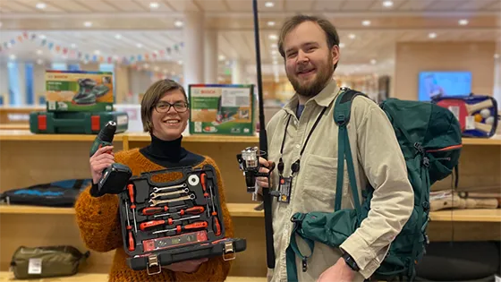 Two people smiling, showing off tools and equipment from the Library of Things