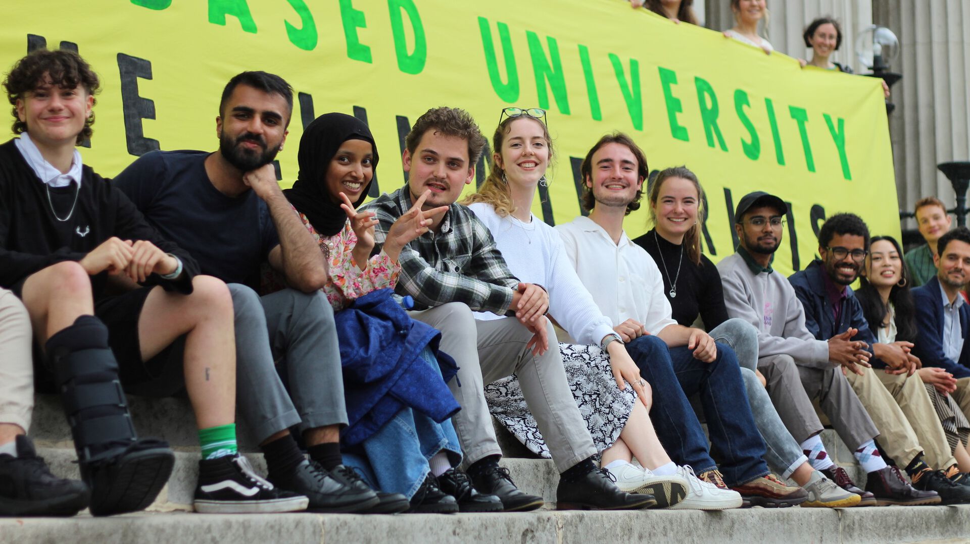 Students sitting on a row in front of a PBU banner. 