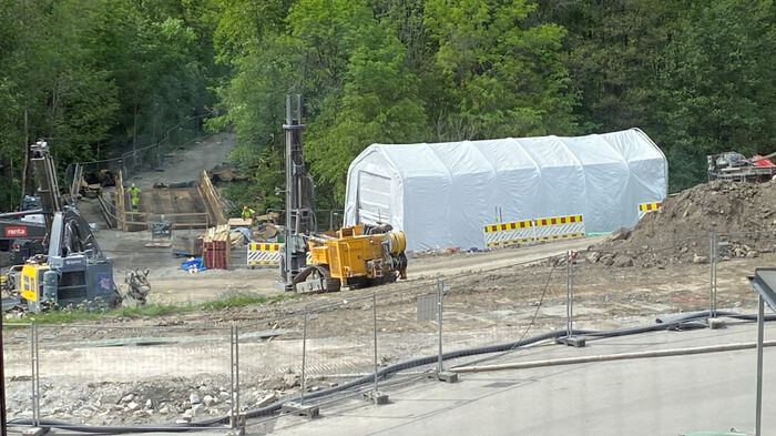 Image shows a white tent in a construction site