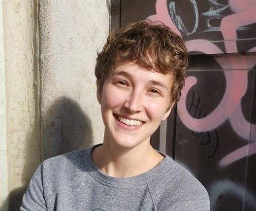 Profile photo of a young, caucasian woman with short hair. She is smiling. 