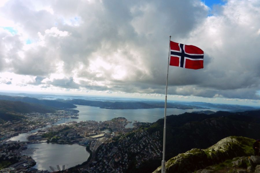 Photo of Norwegian flag over scenic view of a valley