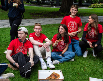 Faddere koser seg med pizza sammen med de nye studentene. Foto: Silje Naranjo/UiO.