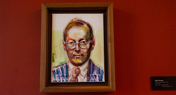 Foto av oljemaleri, et portrett av Viggo Hagstrøm hengt opp på en rød vegg.