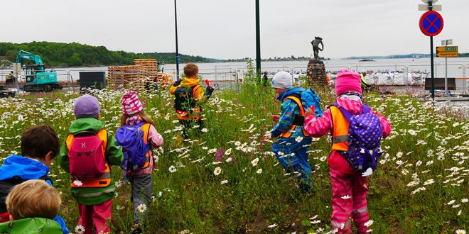 Barn i blomstereng på jakt ette.