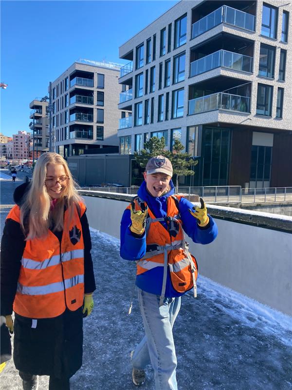 Faciliator and student at Sørenga wearing reflex vest and gloves from Fjord Cleanup