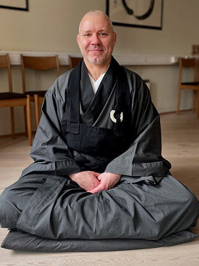 Portrait of Buddhist conversation partner Shindо sitting on the floor