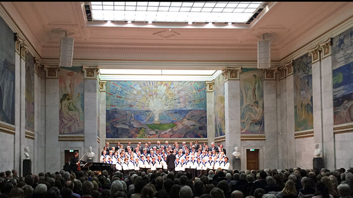 Sølvguttene som holder konsert i Aulaen foran store Munch-malerier
