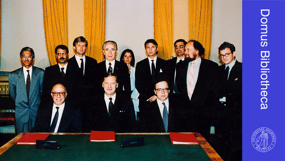 Bilde av menn bak et bord som har inngått Oslo-avtalen