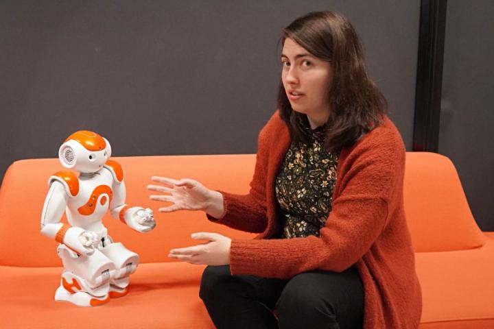 En forsker på sofaen sammen med en robot.