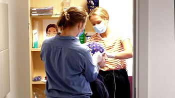 Two student assistants prepare EEG capture on a subject in the FRONT Neurolab, following the current corona measures.