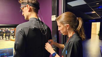 Laura Bishop checks that both the eye-tracking glasses and motion capture suit are ready to be tested by conductor Øyvind Bjorå.