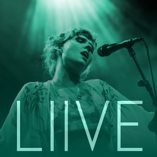 A woman singing in a microphone with the text "Live". Photo.