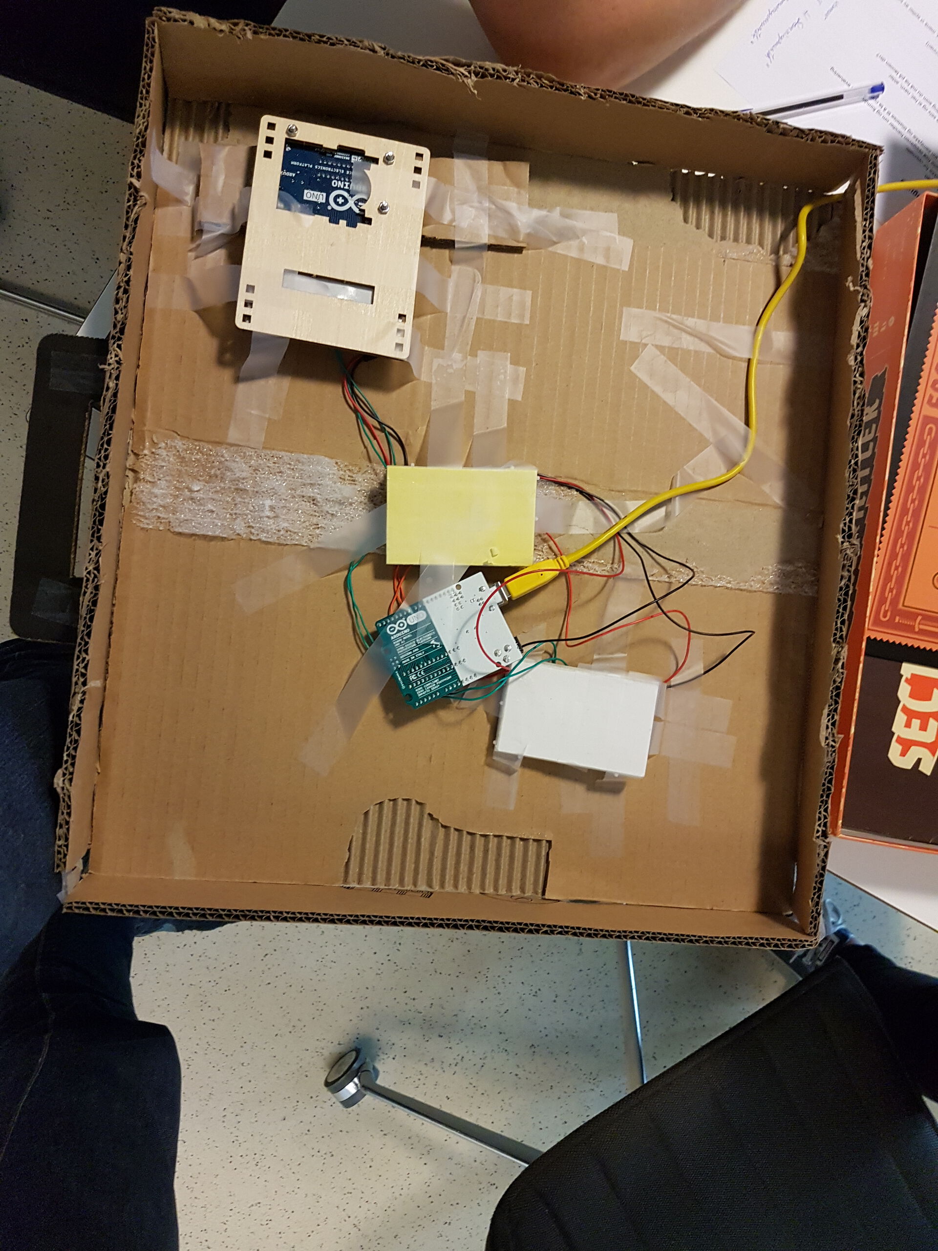 Undersiden av samme boks som i bildet over, viser en arduino med tre breadboards koblet til.
