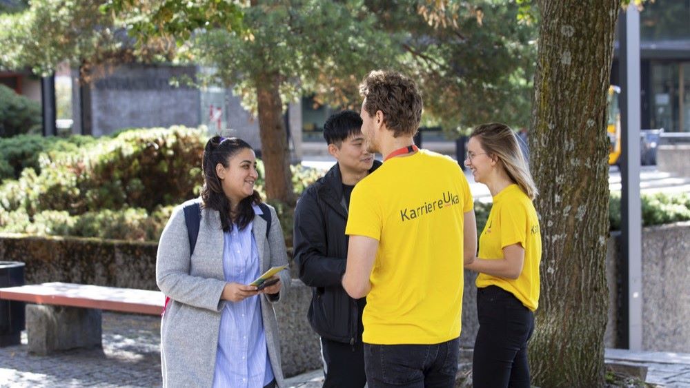 Studenter snakker med representanter fra karriereuka utendørs på campus