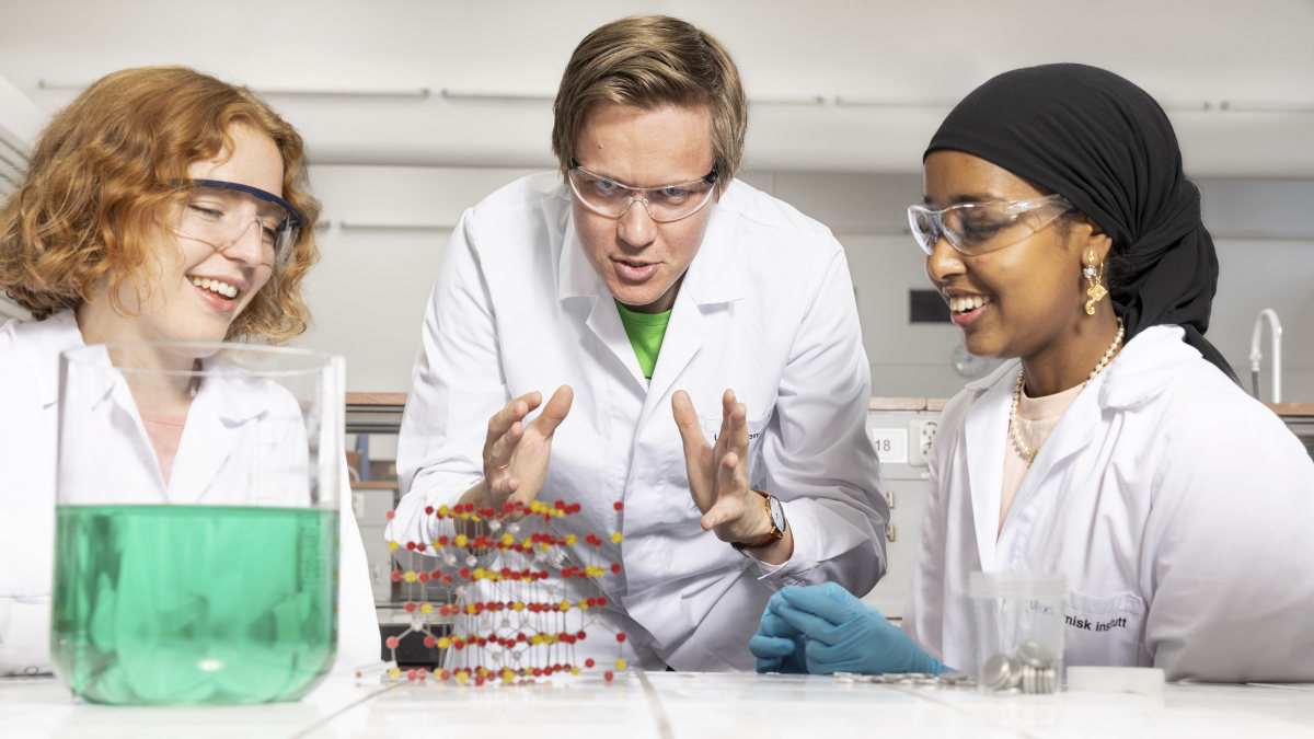 Tre studenter i fokusert arbeid på lab