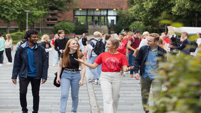 Studenter som går sammen med en fadder på campus.