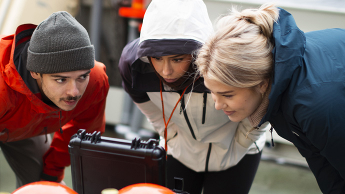Studenter foran teknisk instrument på feltarbeid i Oslofjorden