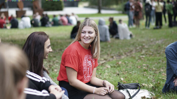 Two female students sitting on a lawn