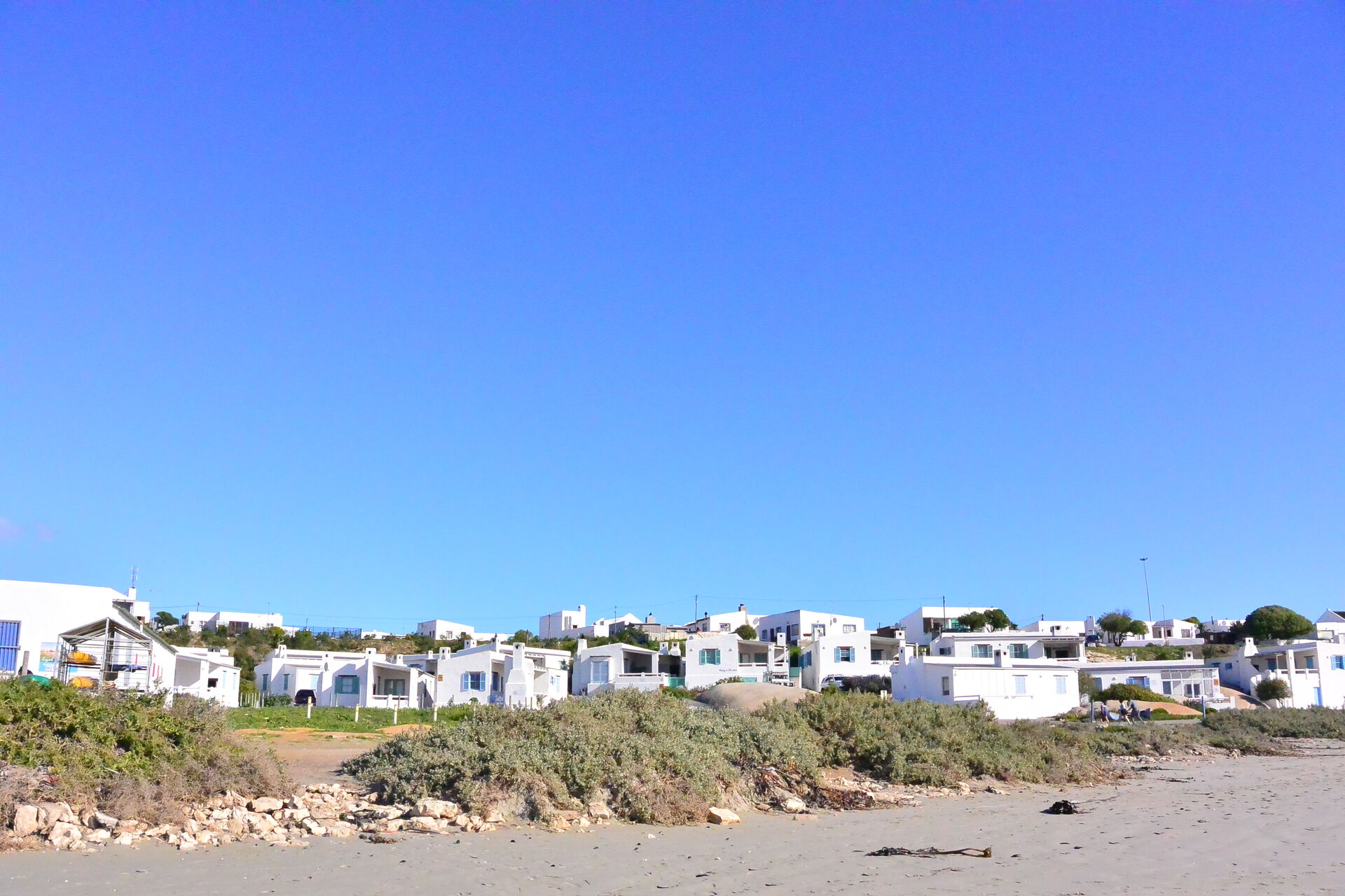 Mange hvite hus som ligger tett på en strand