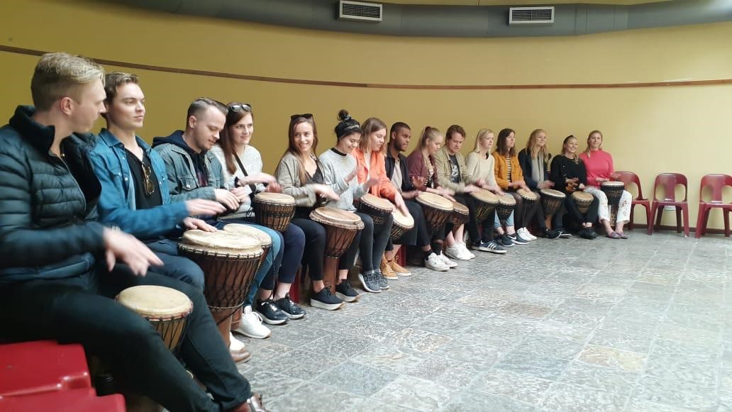 Studenter spiller tradisjonelle trommer.